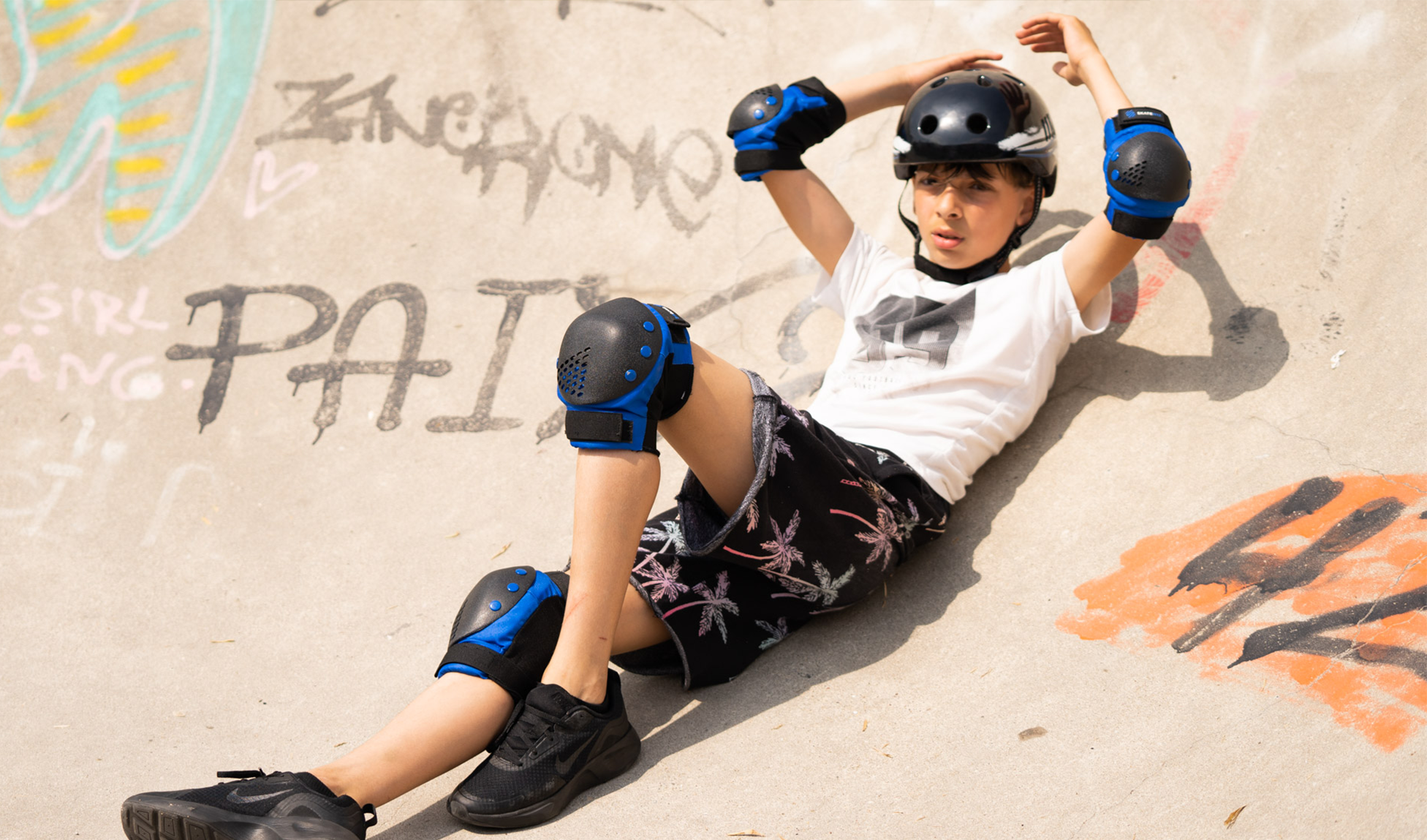 Ein Jugendlicher macht im Skatepark eine Pause und lehnt sich in die Beton Transition