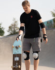 Junger Vater in Skateschutzausrüstung in einem Skatepark